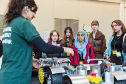 Group of engineering summer school students working on model of car