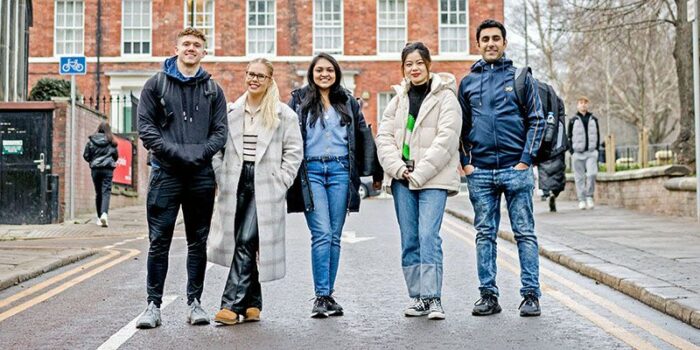 A group of students standing outside on a campus road.