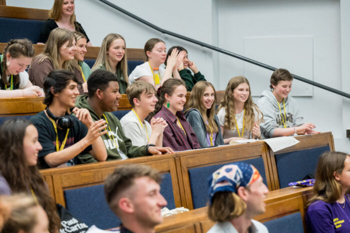 A group of young students sitting in a lecture theatre.