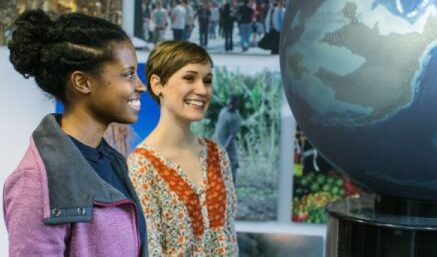 Students looking at a globe.